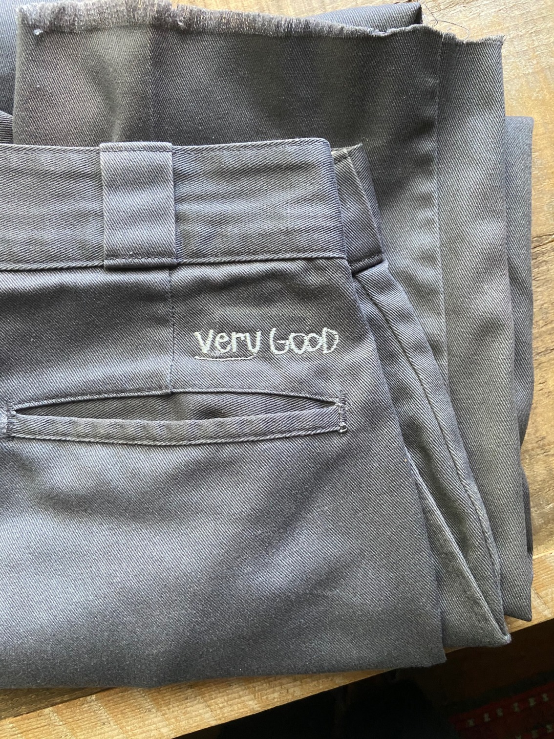 The phrase 'Very Good' embroidered on a pair of pants